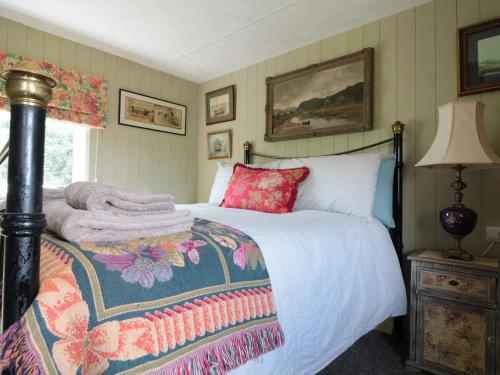 een slaapkamer met een bed met een deken erop bij Crows Cabin in Gloucester