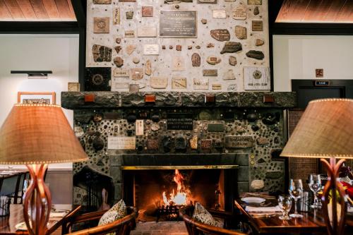 a fireplace in a restaurant with two lamps at Kilauea Lodge and Restaurant in Volcano