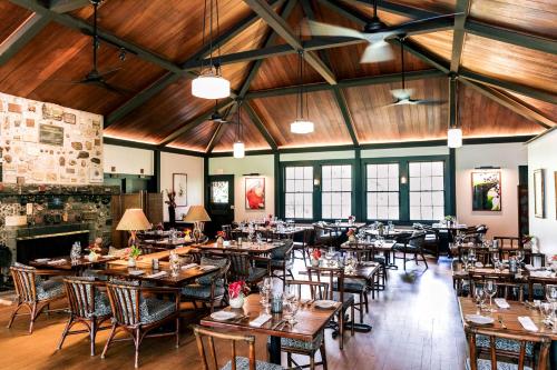 ボルケーノにあるKilauea Lodge and Restaurantの木製の天井、テーブルと椅子のあるレストラン