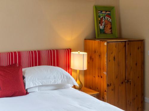 a bedroom with a white bed with a red pillow at The Old School in Omagh