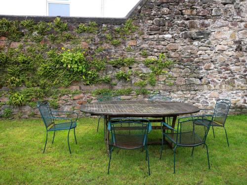 a table and chairs in front of a stone wall at The Old School in Omagh
