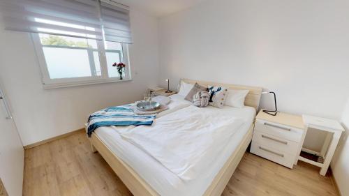 um quarto branco com uma cama e uma janela em Villa Meeresrauschen Ostseetraum em Pelzerhaken