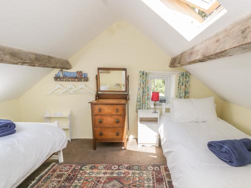 a attic bedroom with two beds and a mirror at Ael Y Bryn in Menai Bridge