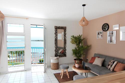 a living room with a couch and a view of the ocean at Ocean View and Exclusive Flat Le croisieriste in Pointe-à-Pitre