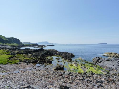 a rocky shore with the ocean in the background at Grebe Cottage in Oban