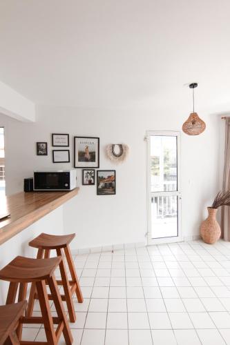 a white kitchen with a counter and two stools at Ocean View and Exclusive Flat Le croisieriste in Pointe-à-Pitre