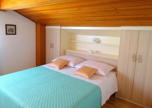 a bedroom with a bed with two pillows on it at Apartments Horvat in Crikvenica
