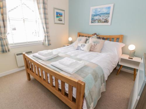 a bedroom with a large bed with two towels on it at Grebe Cottage in Oban