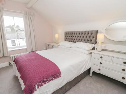 sypialnia z dużym łóżkiem i lustrem w obiekcie Mor Awel w mieście Beaumaris