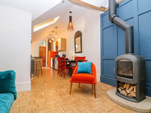a living room with a fireplace and a red chair at The Hemmel in Faringdon