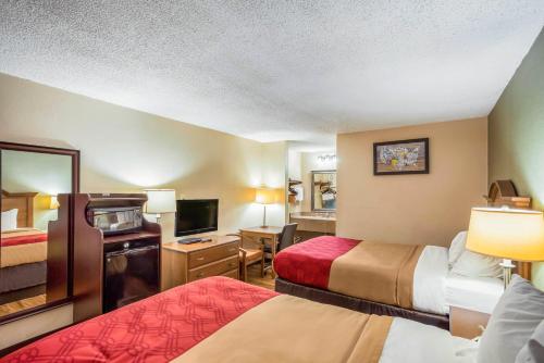 a hotel room with two beds and a television at Econo Lodge Huntington - Barboursville University Area in Huntington