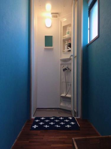 a hallway with a door with a rug on the floor at Sakai Guest House AMAMI（堺ゲストハウス奄美） in Setouchi