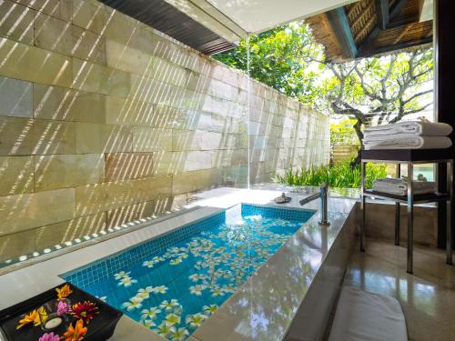 uma piscina no meio de uma casa em The Bale Nusa Dua by LifestyleRetreats em Nusa Dua