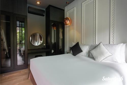 a bedroom with a white bed and a mirror at Saturdays Residence by Brown Starling in Rawai Beach