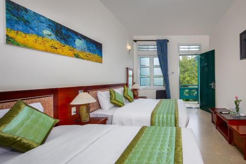 a hotel room with two beds and a window at Sai Gon Phong Nha Hotel in Phong Nha