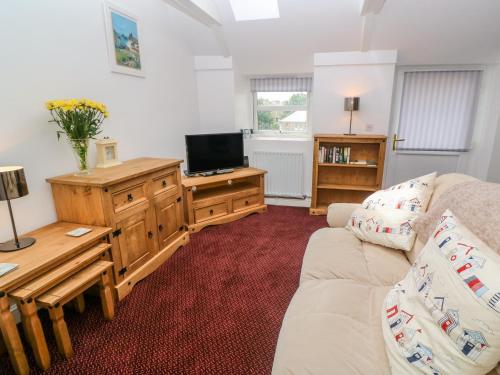 a living room with a couch and a tv at The Stables in Penzance