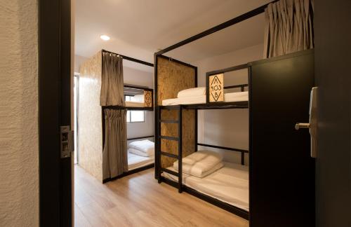 嘉義市的住宿－仲青行旅嘉義館，带两张双层床的客房和门廊