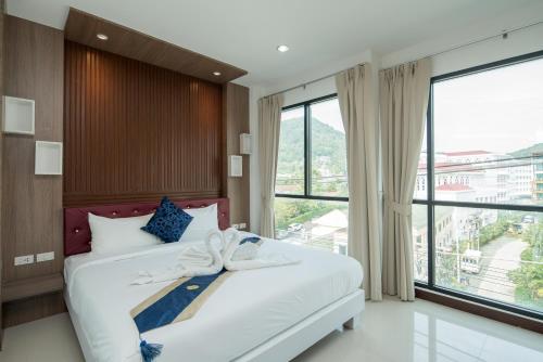 a bedroom with a bed with a bow on it at Baan Thai Beach Side Residence in Patong Beach