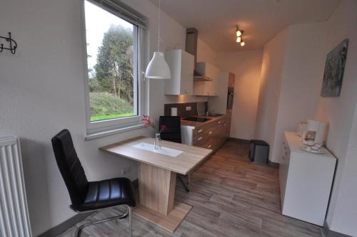 una pequeña cocina con una mesa de madera y una ventana en 50147...., en Carolinensiel