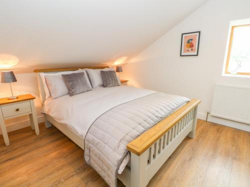 a bedroom with a white bed with a wooden floor at The Croft in Chorley