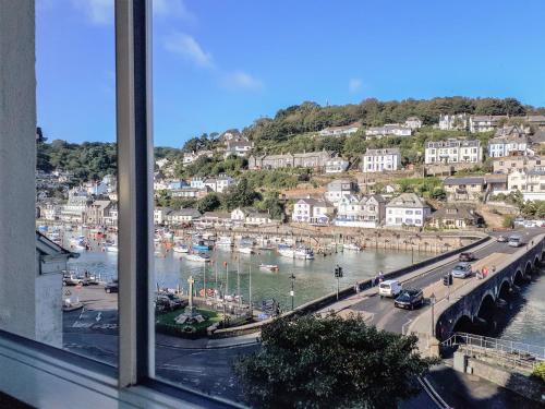 a window view of a harbor with boats in the water at Harbour View Apartment in Looe