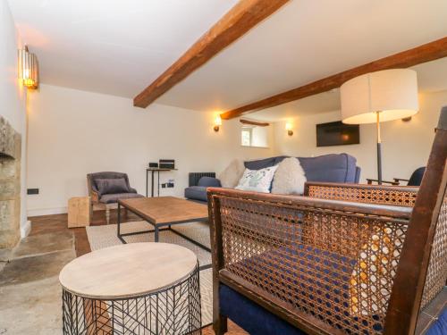 a living room with a couch and a table at Easter Cottage in Burford