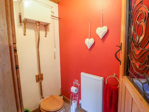 a bathroom with a toilet and hearts on the wall at Woodland Lodge in Alfreton