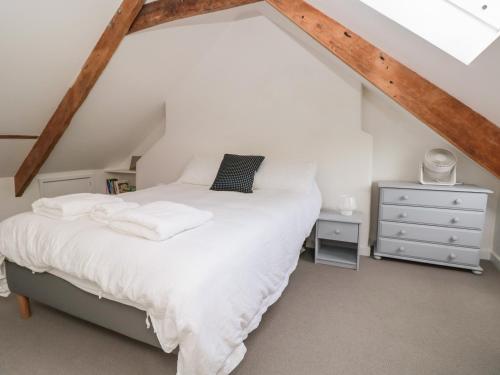 a bedroom with a white bed in a attic at 2 Court Cottages in Kingsbridge