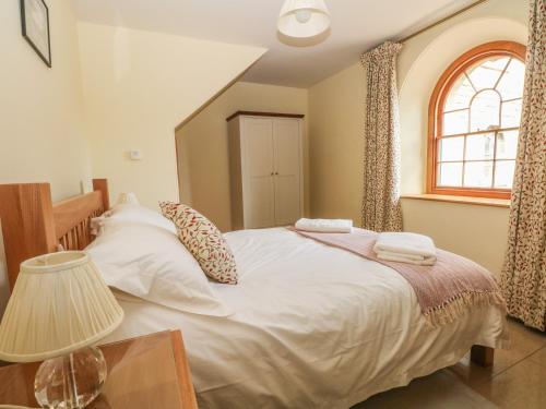 a bedroom with a large white bed and a window at Elmwood in Buxton