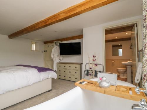 a bedroom with a large bed and a bathroom at The Aspens in Barnard Castle