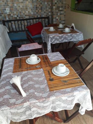 due tavoli con piatti e ciotole in cima di Cantinho da Cineka a Caraíva