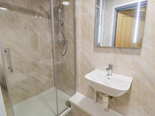 a bathroom with a sink and a shower at Cilan Lodge in Corwen
