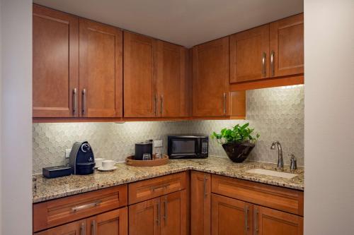 a kitchen with wooden cabinets and a sink and a microwave at Hyatt Regency Orlando International Airport Hotel in Orlando