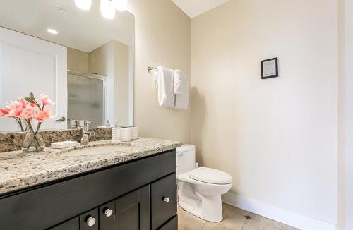 een witte badkamer met een toilet en een wastafel bij Stunning Apartments Close to City Attractions in New Orleans