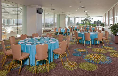 a conference room with blue tables and chairs and windows at Hyatt Regency Orlando International Airport Hotel in Orlando