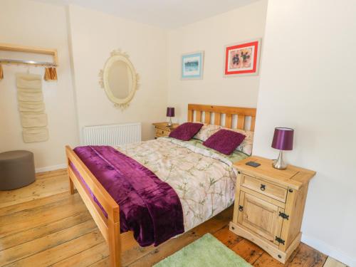 1 dormitorio con 1 cama y 1 mesa con lámpara en Bwthyn Pennant, en Llanfihangel-y-pennant