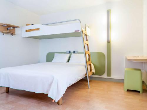 a bedroom with a bunk bed with a ladder at ibis budget Caen Hérouville in Hérouville-Saint-Clair