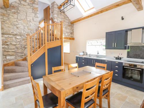 a kitchen and dining room with a wooden table and chairs at The Loft in Mold