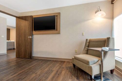 a waiting room with a chair and a flat screen tv at Cambria Hotel Milwaukee Downtown in Milwaukee