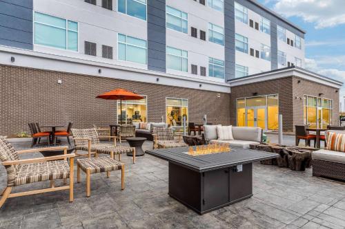 a patio with tables and chairs and a building at Cambria Hotel Milwaukee Downtown in Milwaukee