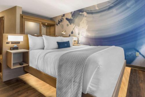 a bedroom with a large bed and a painting on the wall at Cambria Hotel Milwaukee Downtown in Milwaukee