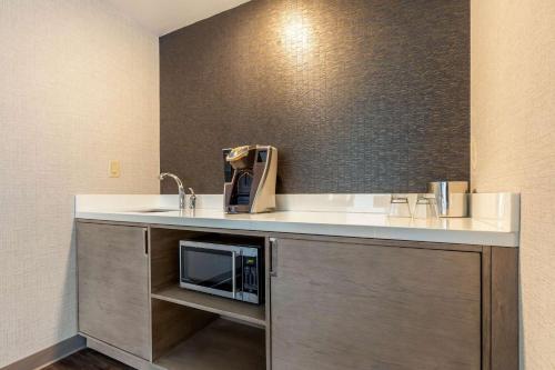 
a kitchen with a sink and a microwave at Cambria Hotel Milwaukee Downtown in Milwaukee

