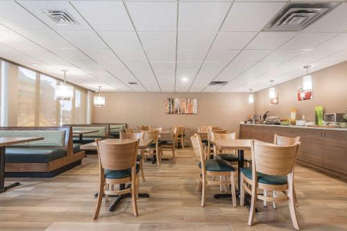 uma sala de jantar com mesas e cadeiras de madeira em Quality Inn & Suites Downtown Windsor, ON, Canada em Windsor
