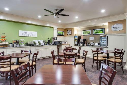 MainStay Suites at PGA Village في بورت سانت لوسي: مطعم بطاولات وكراسي خشبية وكاونتر