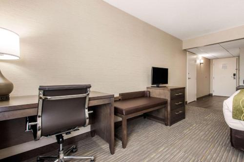a hotel room with a desk with a computer and a bed at Comfort Inn & Suites in Red Deer