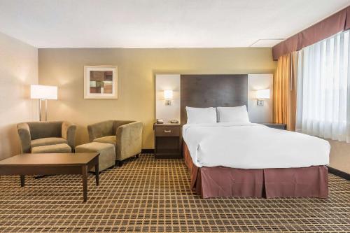 a hotel room with a bed and a chair at Quality Inn & Suites Windsor - Downtown in Windsor