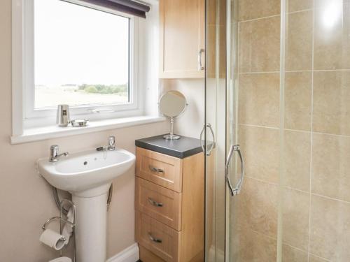 W łazience znajduje się umywalka, lustro i prysznic. w obiekcie Little Lochlair w mieście Forfar