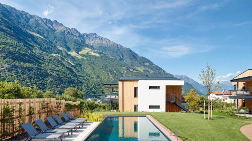 a backyard with a pool and chairs and mountains at Cirna Gentle Luxury Lodges in Naturno