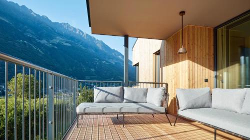 a balcony with two chairs and a view of a mountain at Cirna Gentle Luxury Lodges in Naturno