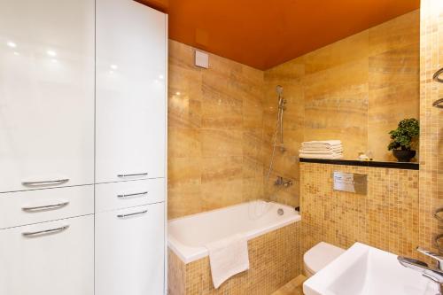 a bathroom with a bath tub and a sink at Audros Apartamentai in Kaunas